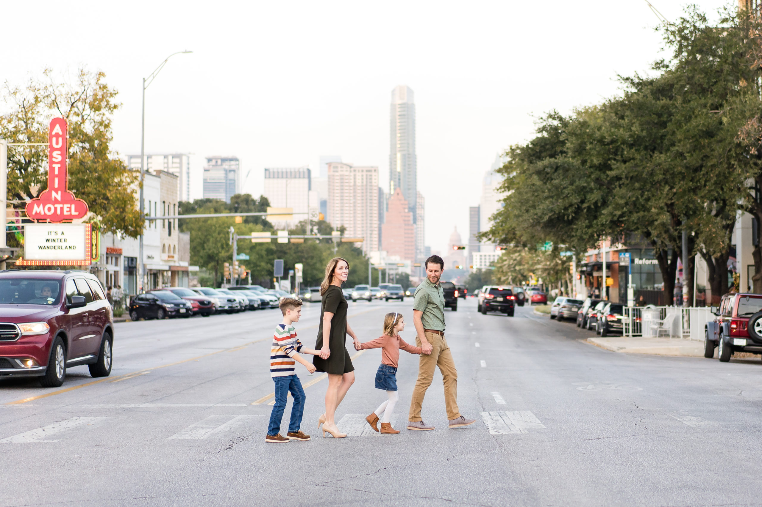 A family crossing the street during their photo session with the best family photographer in Austin, Alissa Cordoba