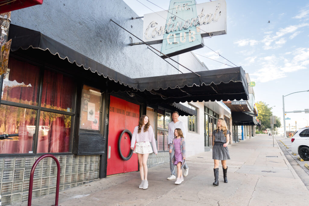 A family walking down the streets of Austin, Texas, enjoying one another's company while having their photos taken.