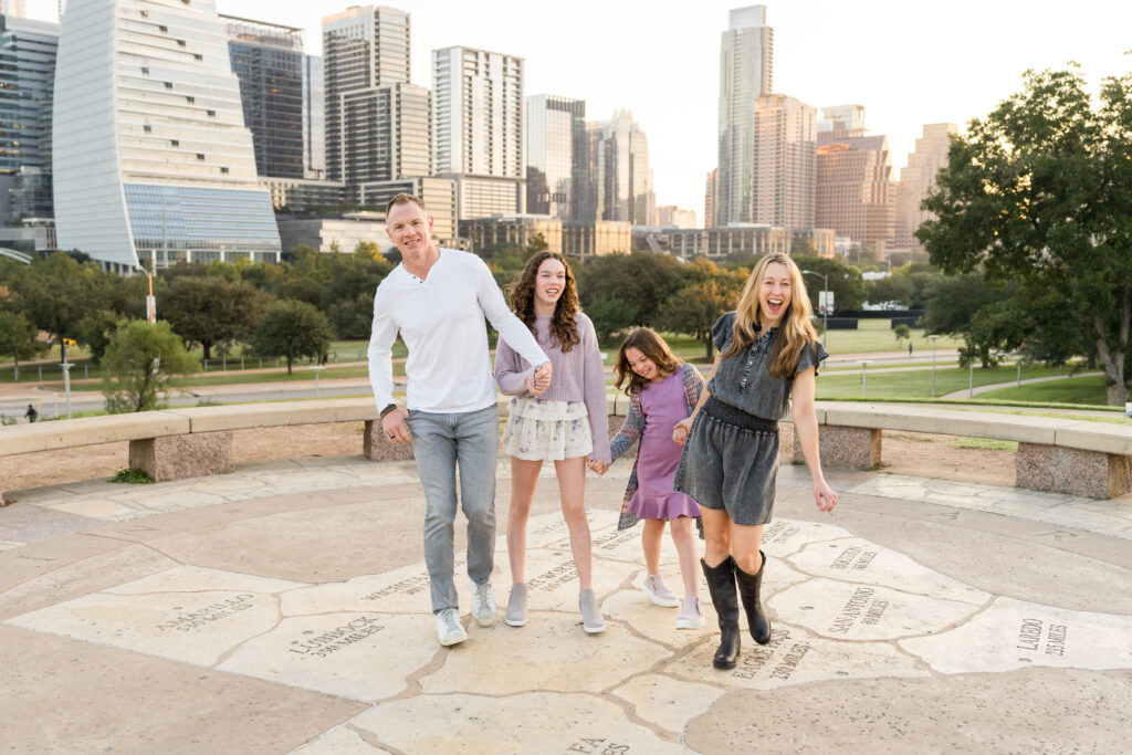 A family laughing during their family session at Butler Park, while photographer Alissa Cordoba takes their photos.