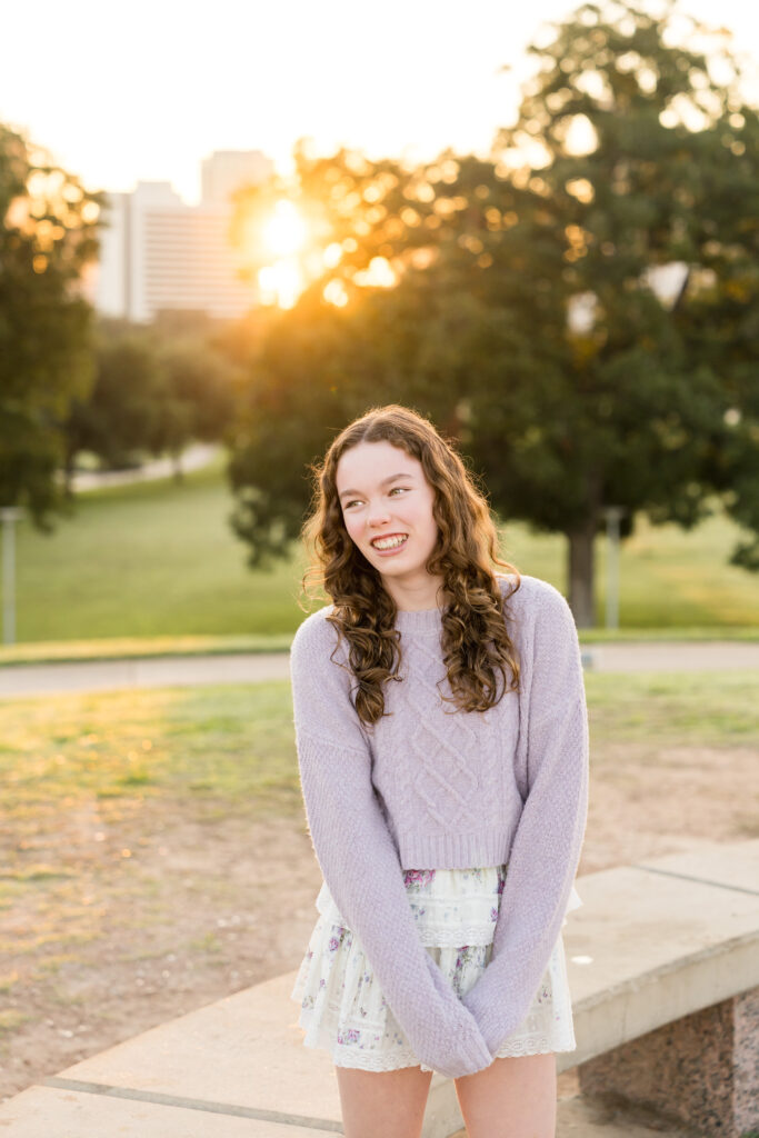 A teenager posing by herself as the sun sets at Butler Park in Austin, Texas.