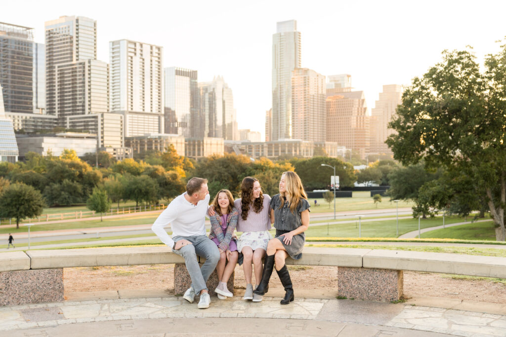 A family sitting down and laughing together as they have their photo taken in Austin, Texas, by family photographer Alissa Cordoba.