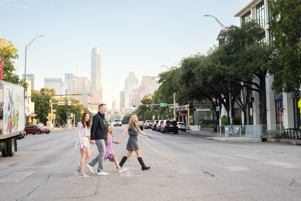 A family holding hands as they cross the street in Austin, Texas.