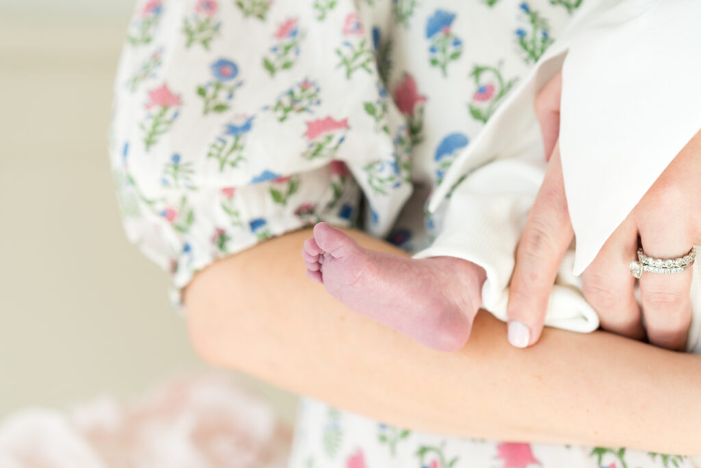 New parents in Austin holding their newborn baby, captured in a bright and candid in-home session.