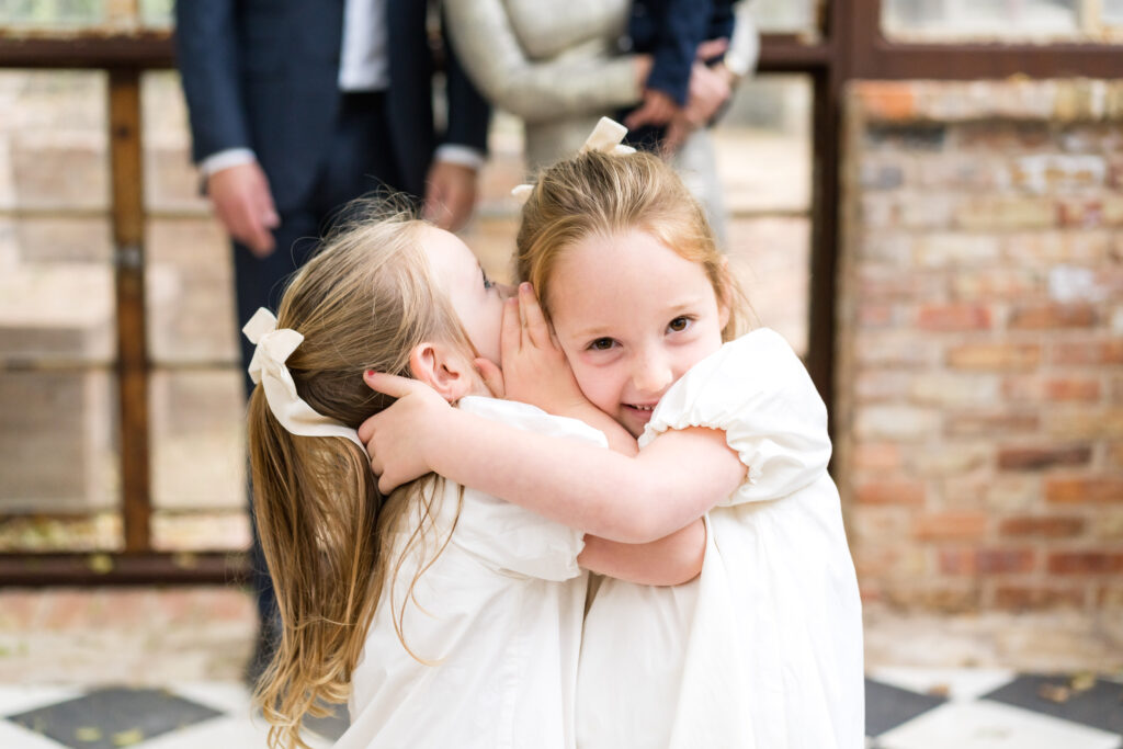 Two sisters giggling, telling secrets as they have their family photos taken in Austin, Texas.