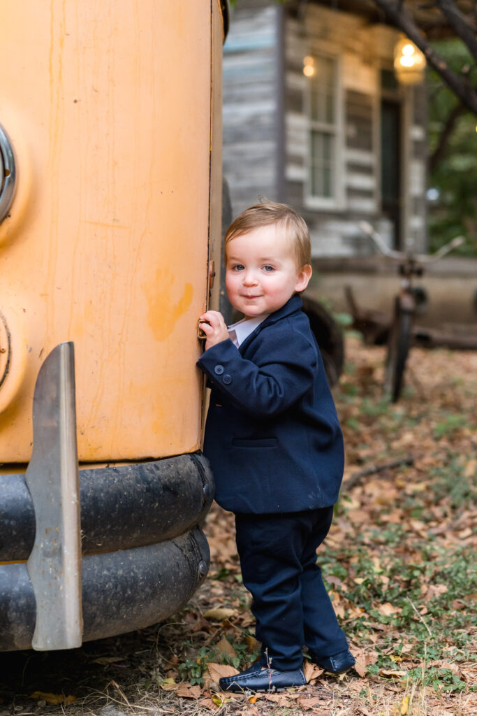 A little boy looking at the camera and leaning up against the bus at Sekrit Theater.