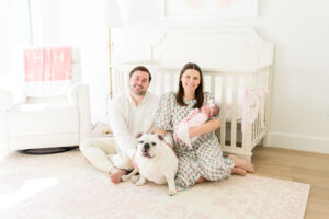 Austin parents holding their newborn daughter in her nursery during their lifestyle newborn session.