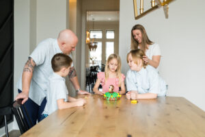 A family playing a game during their in-home family photography session.