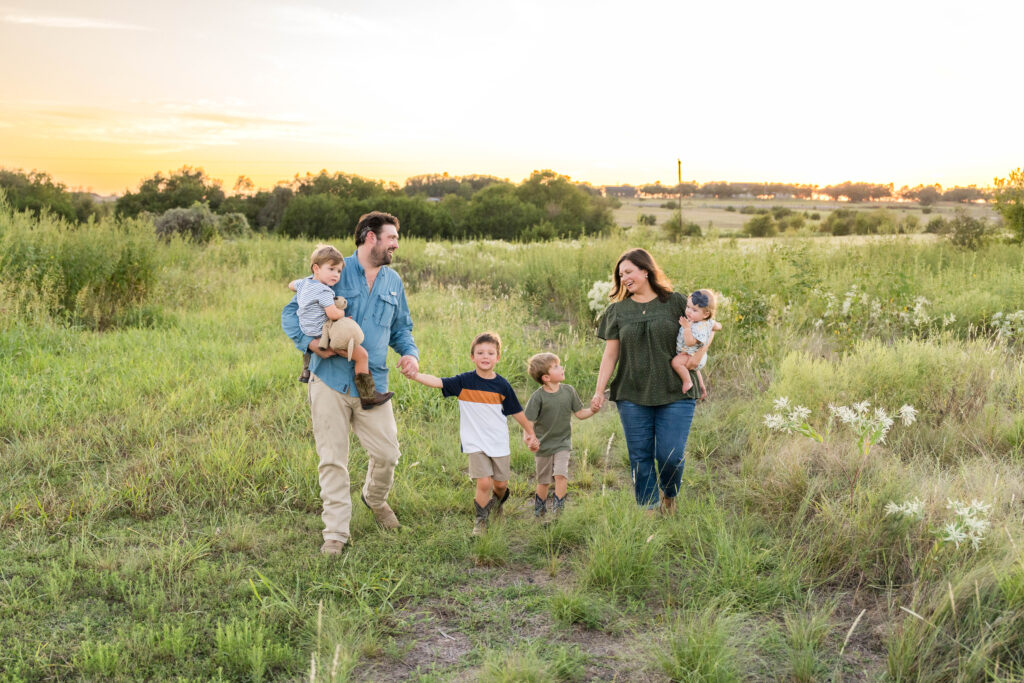 A family of 5 having their photos taken during a sunset session with Alissa Cordoba Photography.
