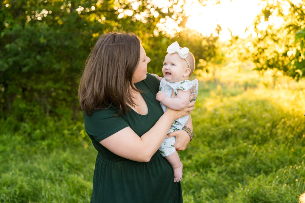 A 6 month old girl being held by her mom during a family photo session with Alissa Cordoba Photography.
