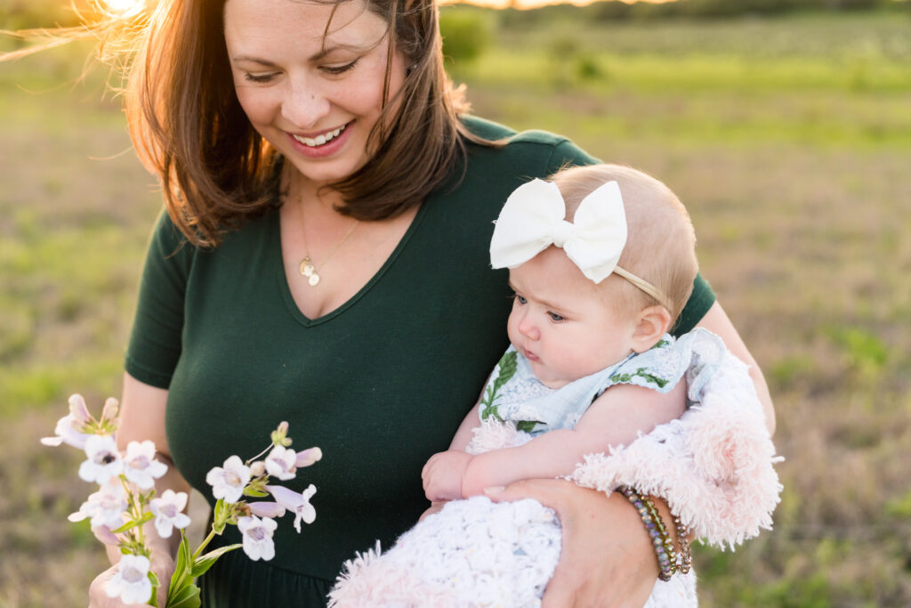 A 6 month old girl being held by her mom during a family photo session with Alissa Cordoba Photography.