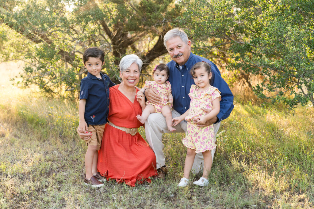 Grandparents walking with their three young grandchildren during a golden hour yearly family photo session in Austin, Texas
