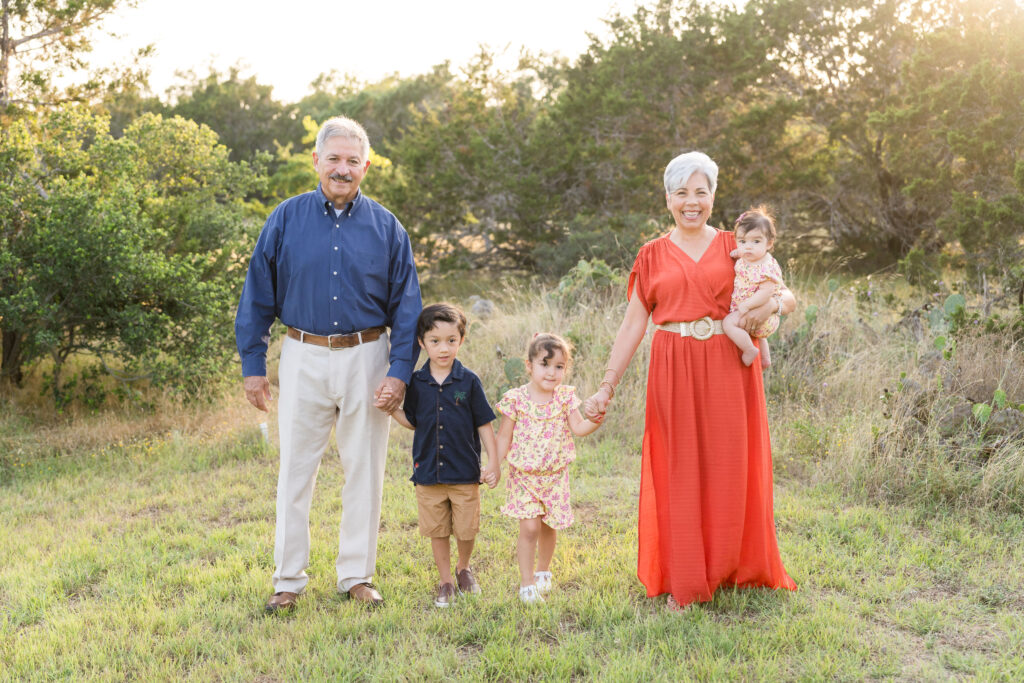 Grandparents walking with their three young grandchildren during a golden hour yearly family photo session in Austin, Texas