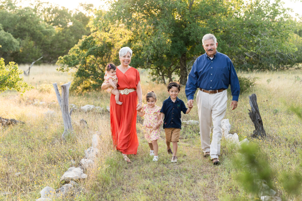 Grandparents walking with their three young grandchildren during a golden hour yearly family photo session in Austin, Texas