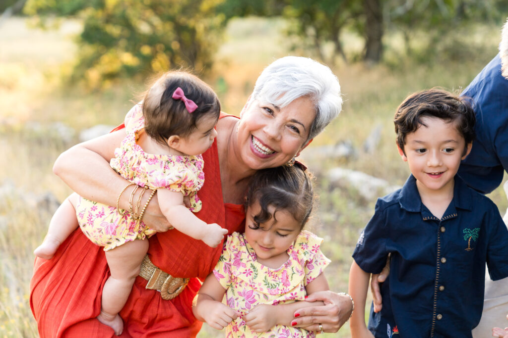 Grandparents walking with their three young grandchildren during a golden hour yearly family photo session in Austin, Texas