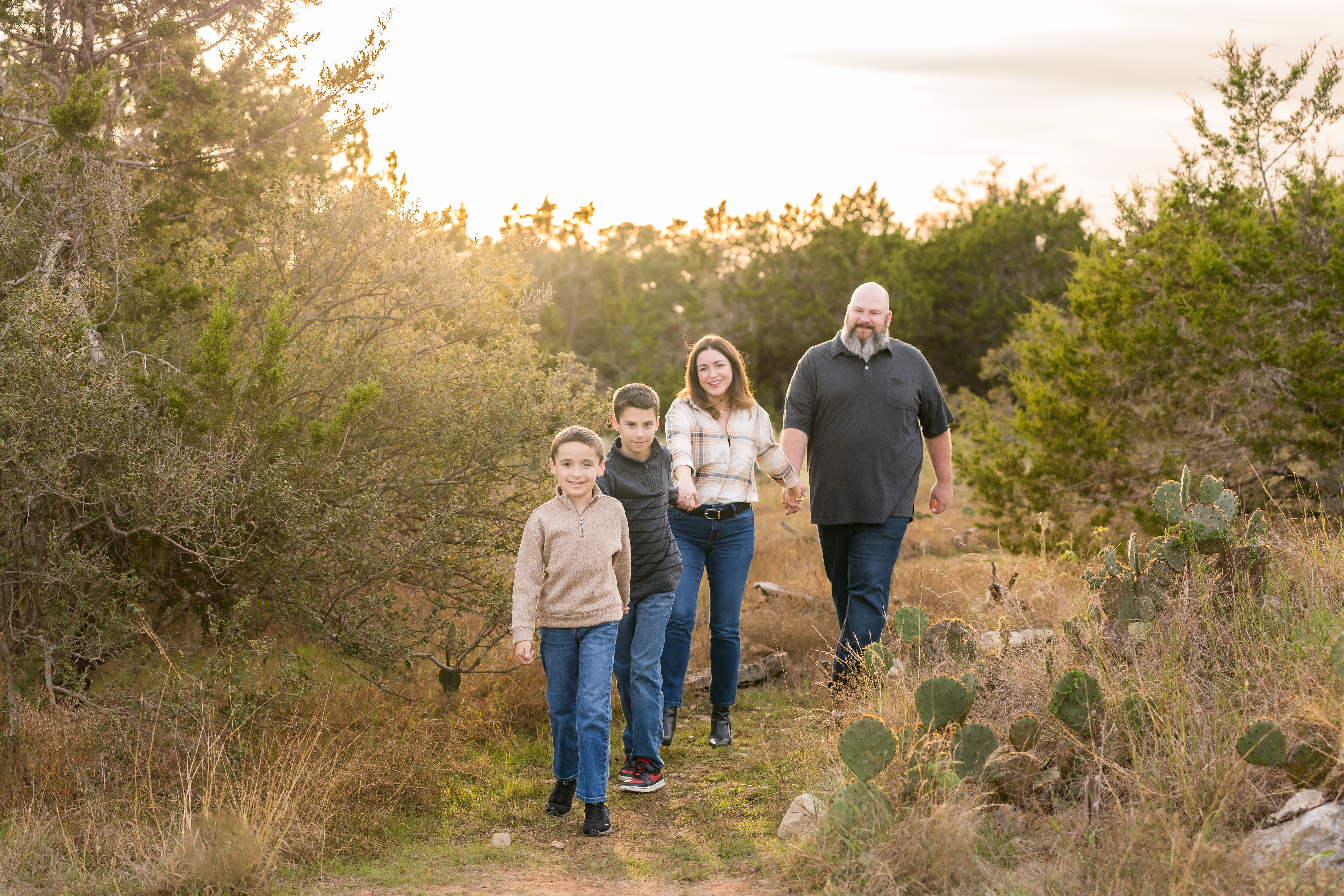A family walking through a field during their family photo session in Austin