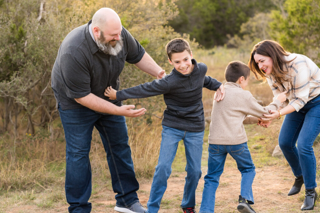 A family being silly as they have their family photos taken in Austin, by Alissa Cordoba Photography.