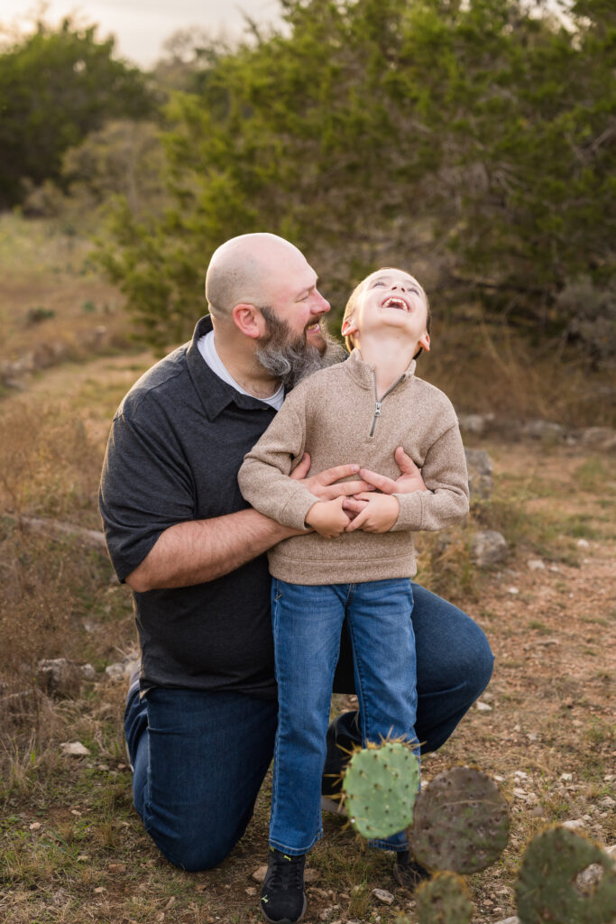 A dad getting his son to laugh during their photo session together in Austin.