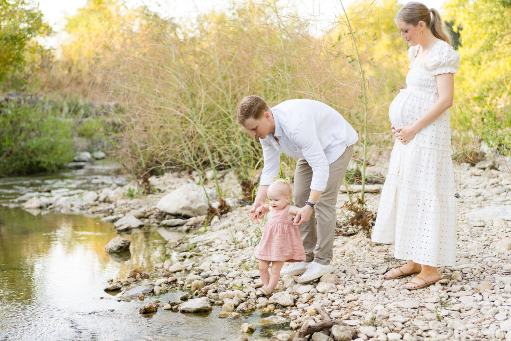 A family doing a maternity photo session at Pease Park in Austin.