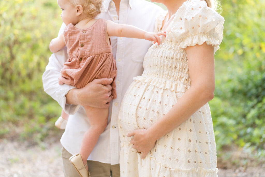 A family doing a maternity photo session at Pease Park in Austin.