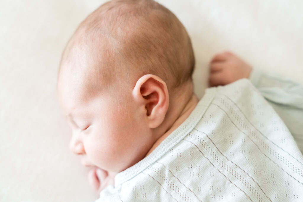 Lifestyle newborn photography captures a sweet newborn sleeping.