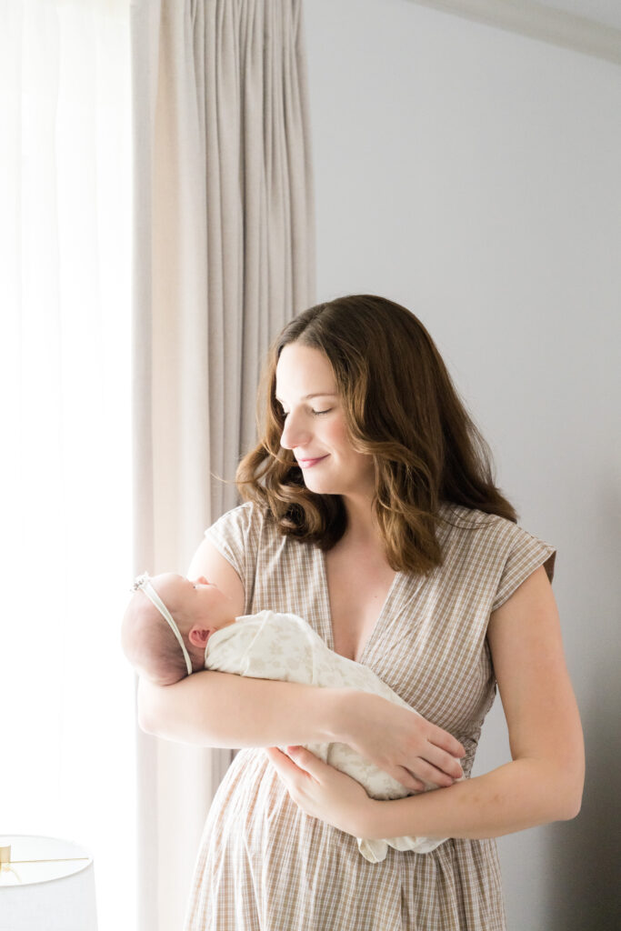 Newborn photo session length example with baby resting peacefully in parents’ arms