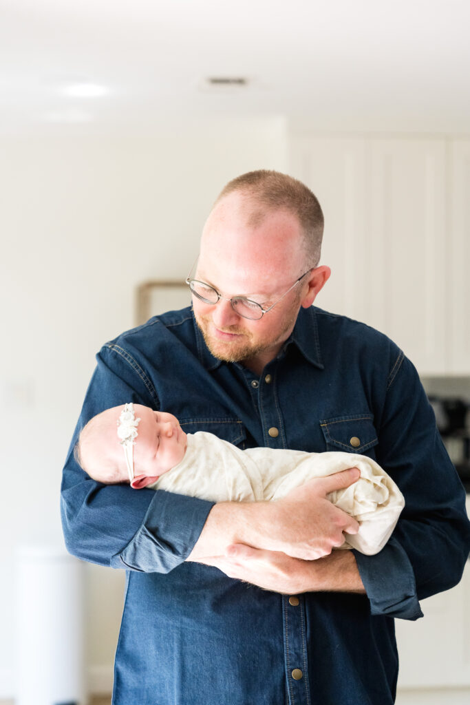 Newborn photo session length example with baby resting peacefully in parents’ arms