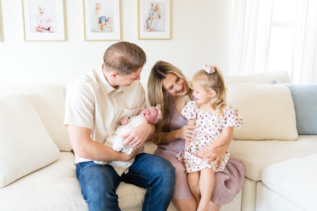 Parents holding newborn during in-home lifestyle session in Austin