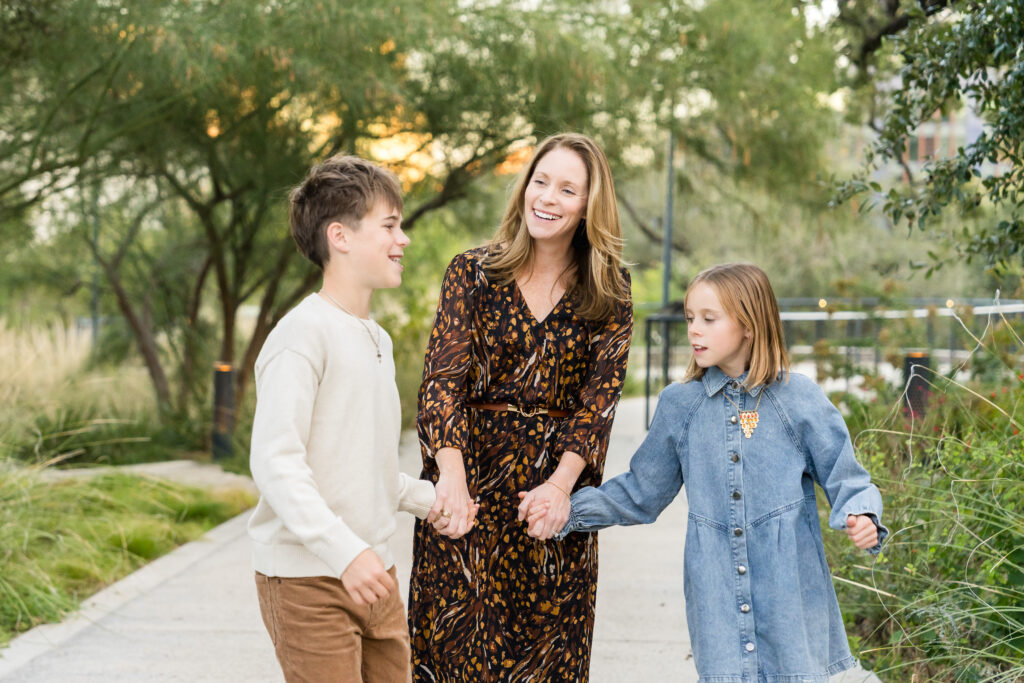 Family walking along the Waterloo Greenway trail during a candid family photography session in Austin